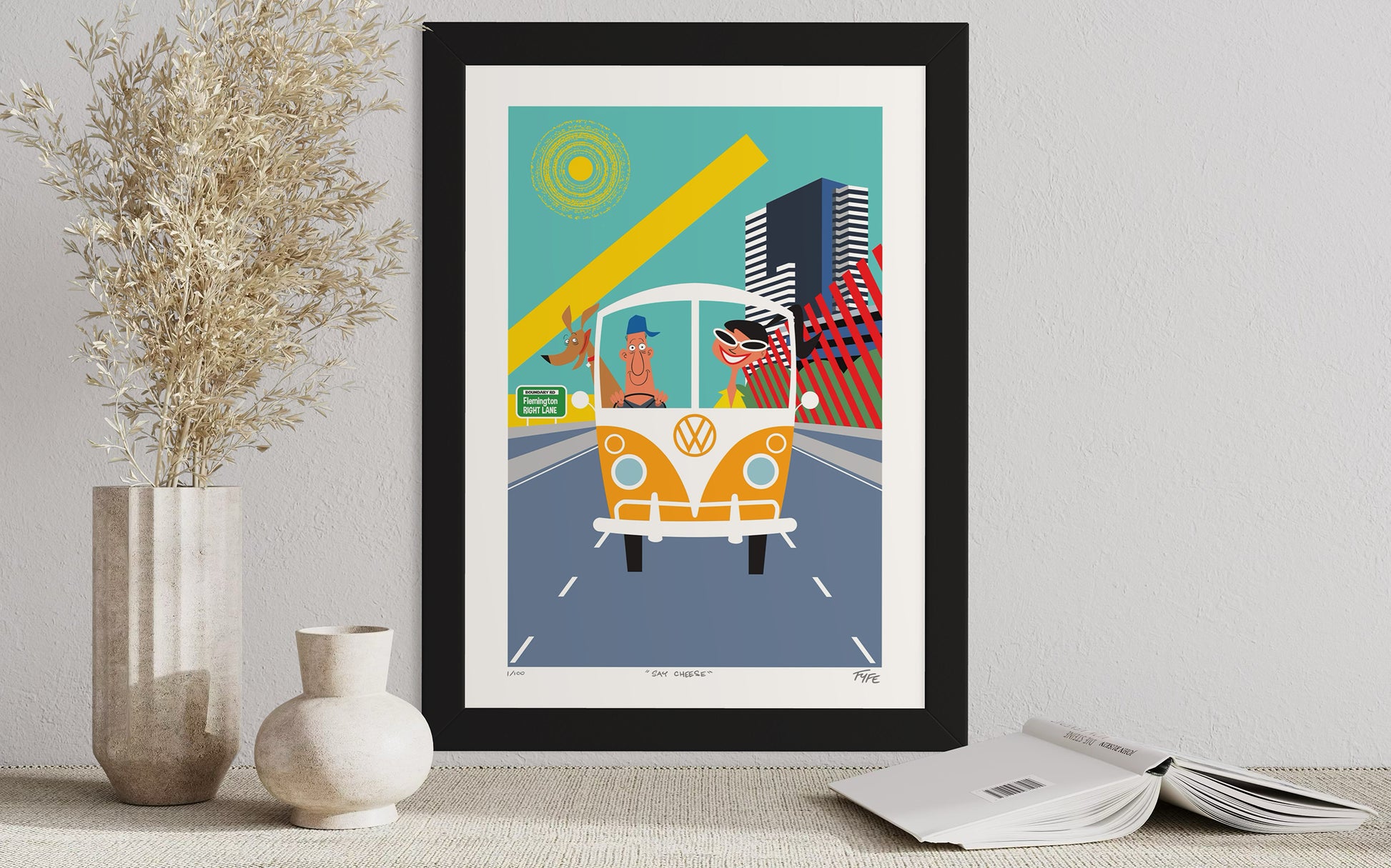 Framed artwork of a vintage van with a colorful background on a table.