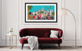 Framed artwork of a colorful cityscape with people on a wall above a red sofa.