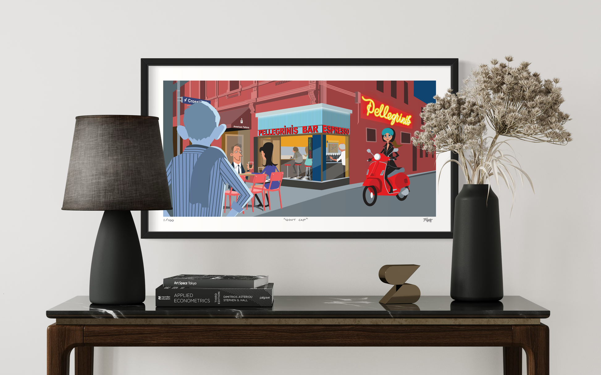Framed artwork of a city street scene on a wall above a wooden console table.