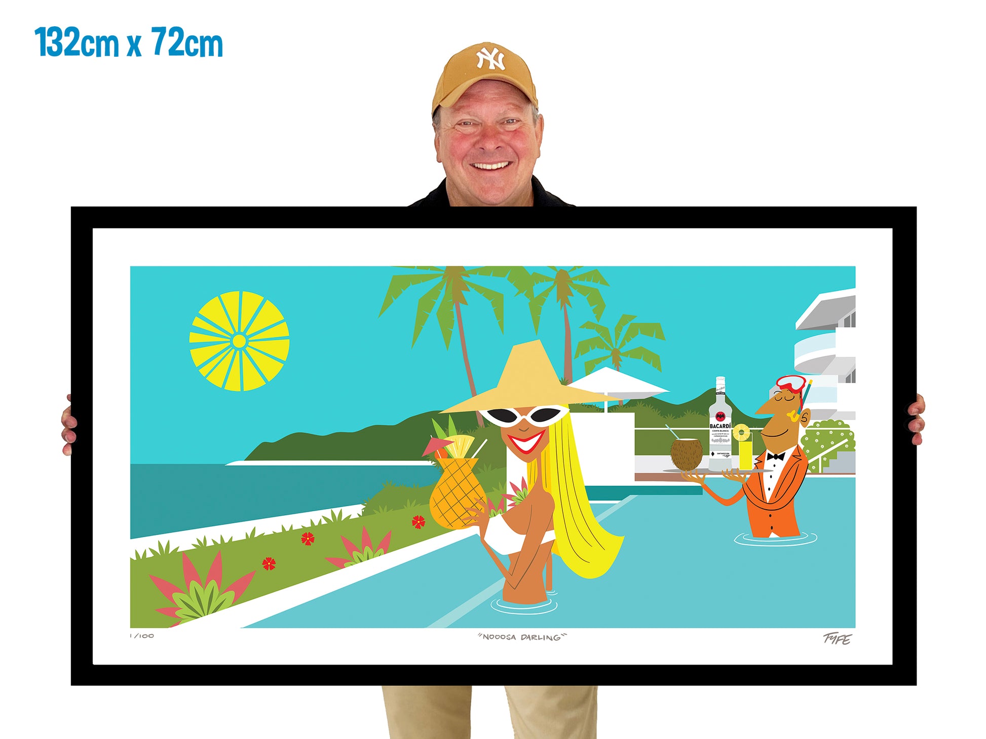 Man holding a large framed artwork of a tropical scene with people by a pool.