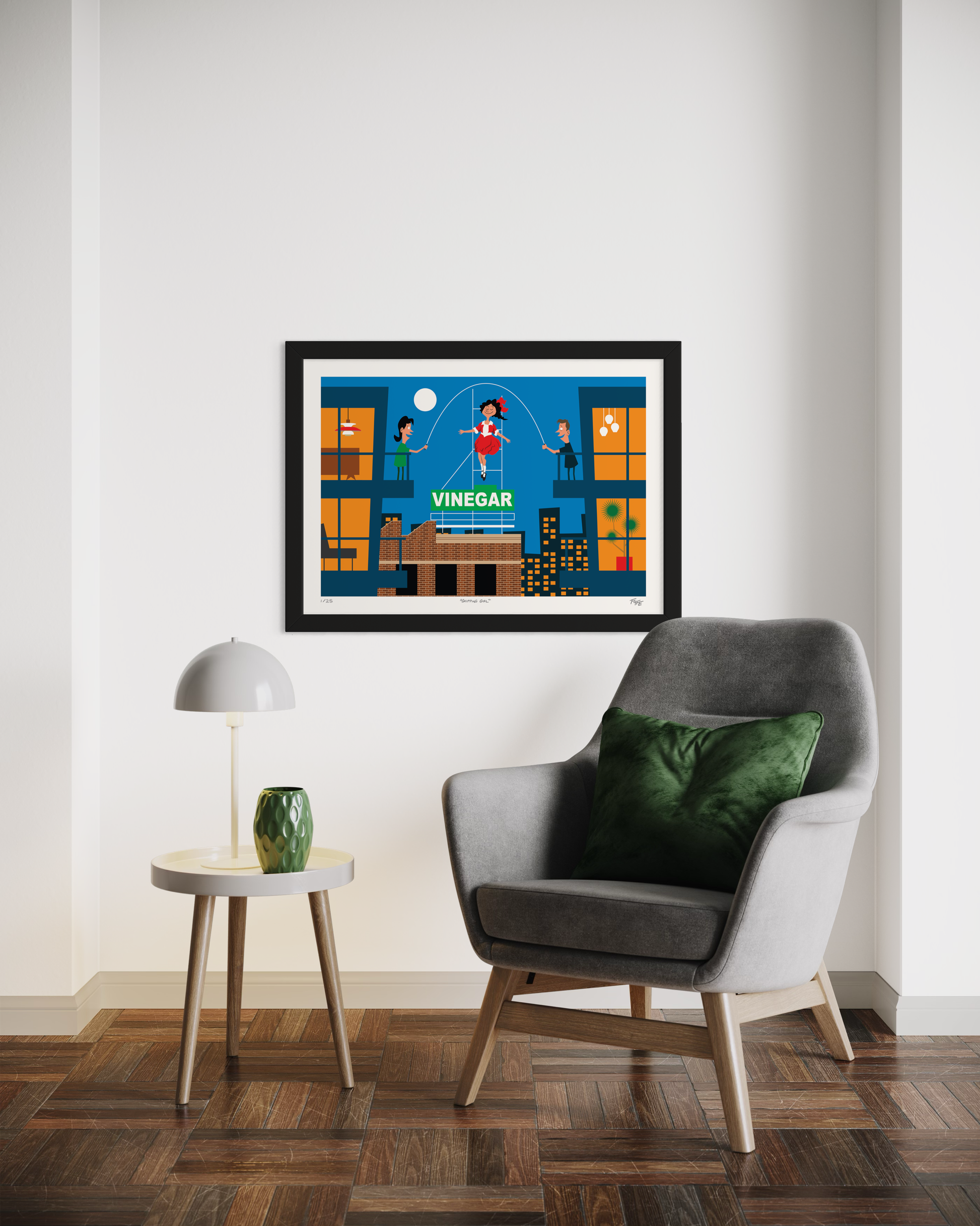 Framed artwork on a wall above a gray armchair with a green pillow.