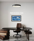 Modern office setup with a desk, chair, and framed picture on a white wall.