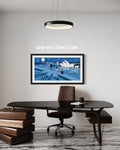 Framed artwork of a cityscape with a desk and chair in a modern office setting.