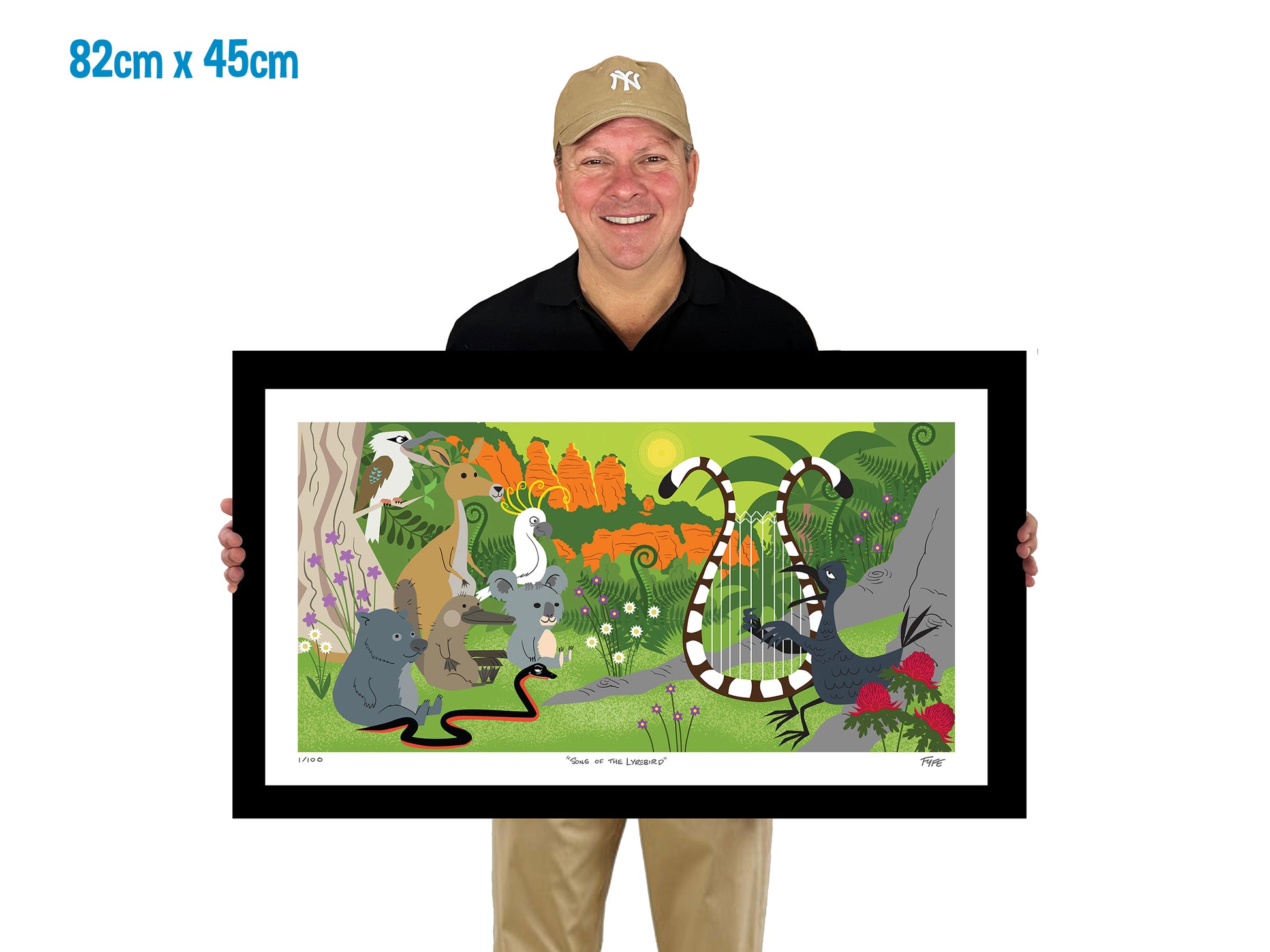 Man holding a framed illustration of animals in a forest setting with dimensions displayed.