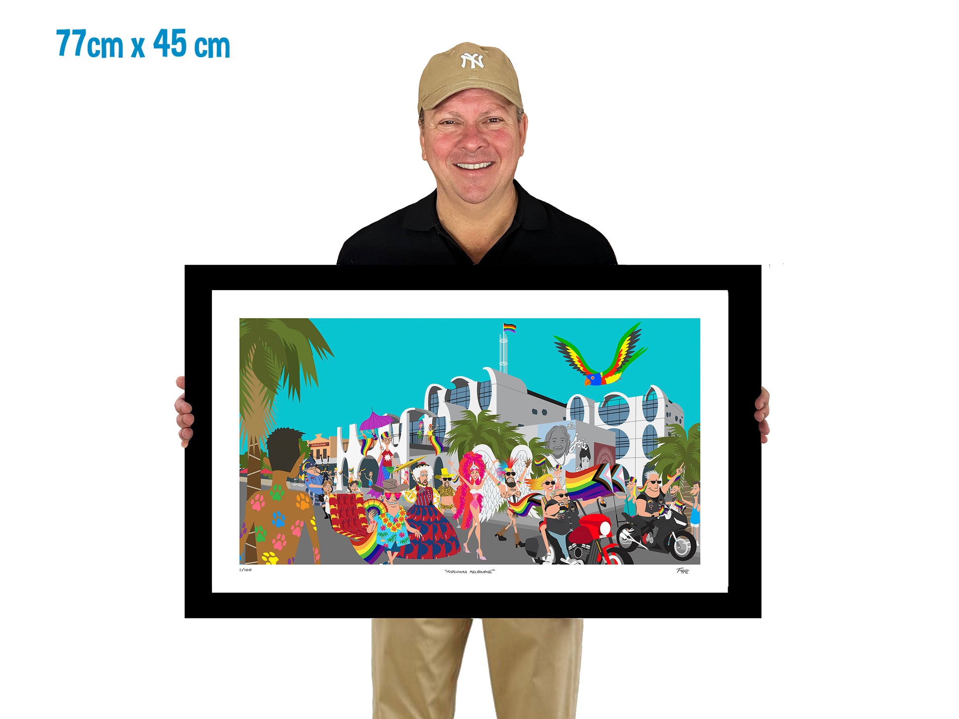Man holding a framed artwork of a colorful scene with people and buildings.