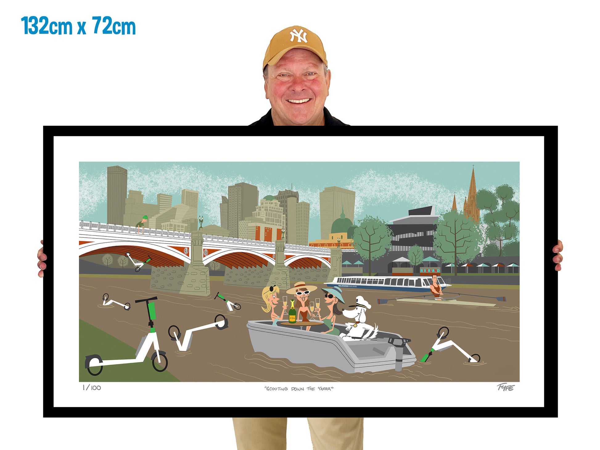 Person holding a framed artwork of a cityscape with people and vehicles.