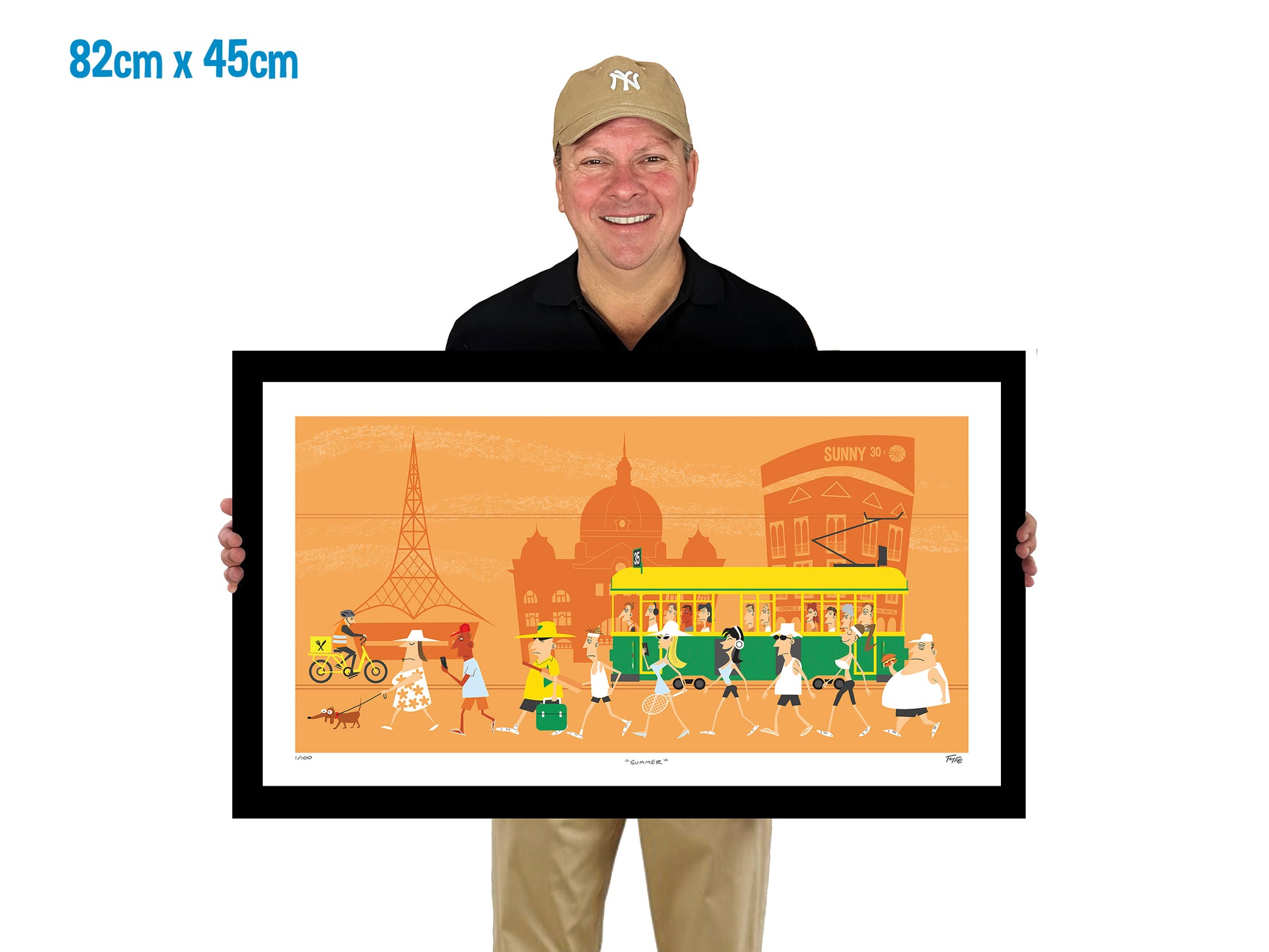 Man holding a framed artwork of a city scene with a tram and people on a white background.