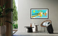 Framed artwork of a tropical scene with palm trees and a beach, displayed in a modern living room.